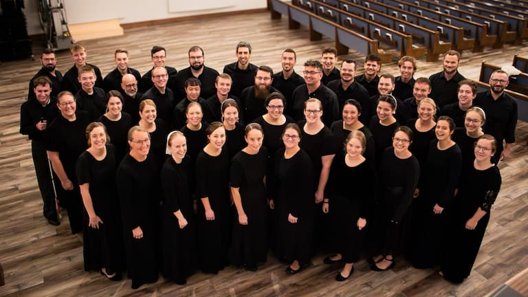 A large group of men and women, dressed in black posing for a group photo