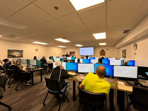 students seated at desks with computers in a technology class