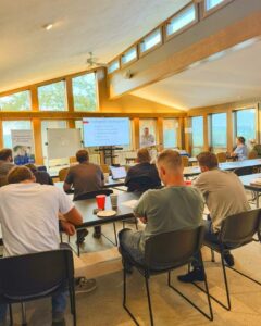 view from the back of a classroom filled with students and a teacher at the front